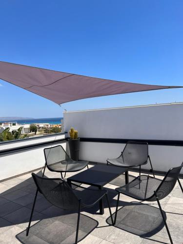 - une terrasse avec 2 chaises, une table et un parasol dans l'établissement Florí, à Reitani