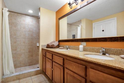 a bathroom with two sinks and a shower at Designer 3BR/2BA Corner Suite - Disney & Universal in Orlando