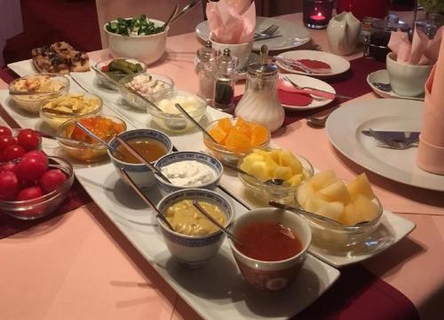 uma mesa com uma bandeja de diferentes tipos de alimentos em Hotel Der Schwan em Einbeck