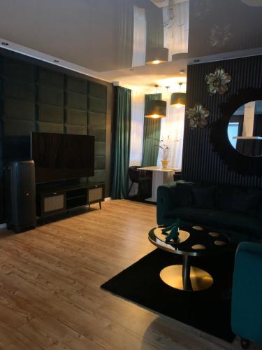 - un salon avec un canapé et une télévision dans l'établissement Lans Apartments SPA Menden Sauerland, à Menden