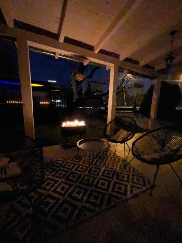 a patio at night with chairs and a table at Verandás Vendégház in Balatonkenese