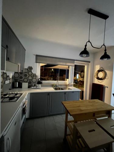 a kitchen with a stove and a table in it at Verandás Vendégház in Balatonkenese