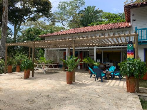 a patio with chairs and a table and a wooden pergola at Casita Caribe en reserva natural, playa privada, kayaks, wifi, aire acondicionado in San Onofre