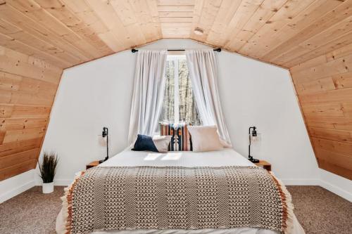 um quarto com uma cama grande e uma janela em Hygge Up North Bungalow em Bellaire