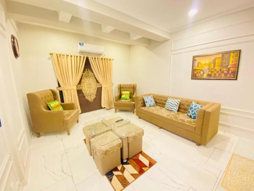 a living room with two couches and a table at Holidazzle Serviced Apartments Bahria Town in Rawalpindi