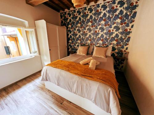 a bedroom with a bed with a floral wall at San Ranieri Tiny Tower in Pisa