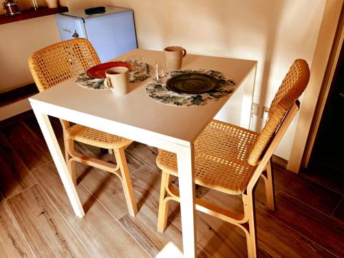 a white table with two chairs and a plate on it at San Ranieri Tiny Tower in Pisa