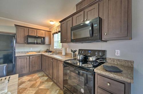 a kitchen with wooden cabinets and a stove top oven at Pet-Friendly Cassopolis Escape with Lake Access in Cassopolis