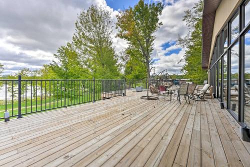 a wooden deck with chairs and tables on a building at Pet-Friendly Cassopolis Escape with Lake Access in Cassopolis