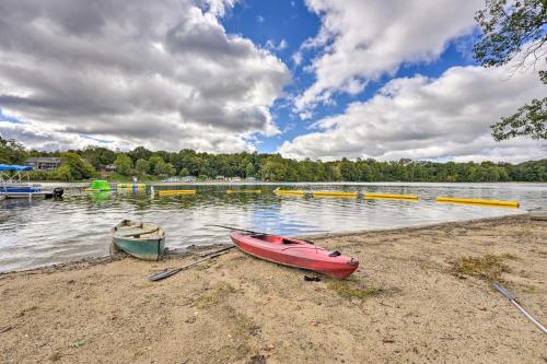 a red boat sitting on the shore of a lake at Cassopolis Cabin, Private Deck and Lake Access! in Cassopolis