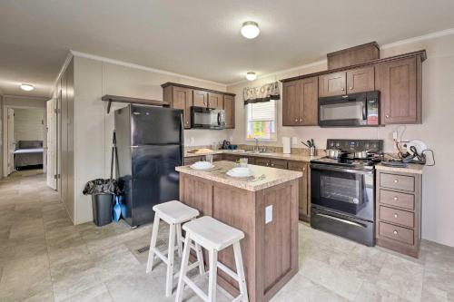 a kitchen with wooden cabinets and a black refrigerator at Cassopolis Cabin, Private Deck and Lake Access! in Cassopolis