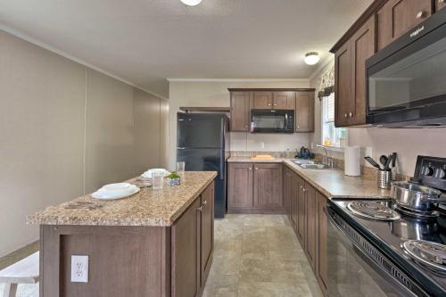 a kitchen with wooden cabinets and a black refrigerator at Cassopolis Cabin, Private Deck and Lake Access! in Cassopolis