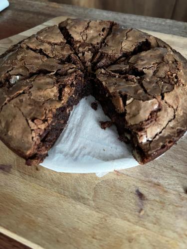 a chocolate cake sitting on top of a wooden cutting board at Condesa in Tirana
