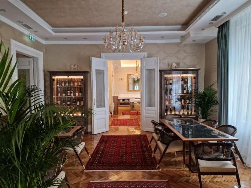 a living room with a table and chairs and a chandelier at Queen Palace in Novi Sad