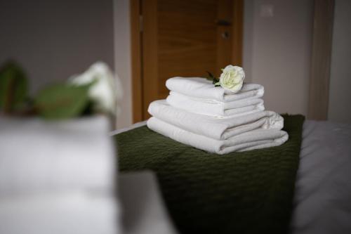 uma pilha de toalhas com uma flor em cima delas em LINA - PG, Moraca River Apartment em Podgorica
