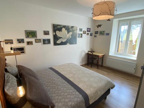 a bedroom with a bed and a window and a desk at La petite marmite du lac de Vouglans in Pont-de-Poitte