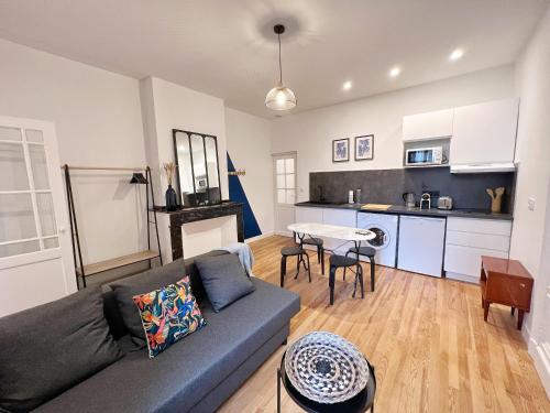 uma sala de estar com um sofá e uma cozinha em Le Cobalt - Hypercentre - Gare - Netflix em Toulouse
