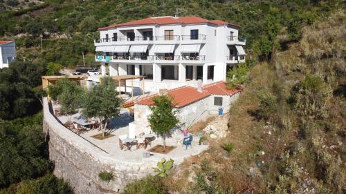 a large white building on the side of a wall at Toni Retzo Rooms in Himare