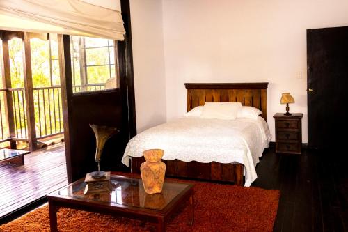 a bedroom with a bed and a table with a coffee table sidx sidx at Hotel Campestre Entre Cerros in Ubalá
