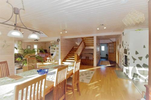 a dining room with a table and chairs and a staircase at Villa Vuopajanranta in Rovaniemi