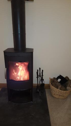 a black stove with a fire in a room at The Granary in Barnstaple