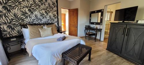 Schlafzimmer mit einem Bett mit einer schwarz-weißen Wand in der Unterkunft Solo Gracia Guesthouse in Bloemfontein