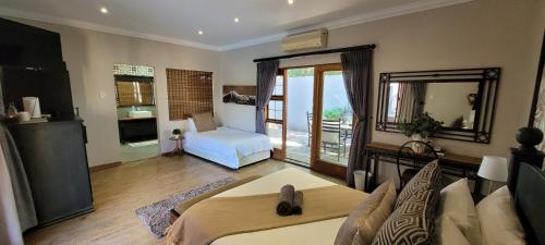 a living room with a bed and a mirror at Solo Gracia Guesthouse in Bloemfontein