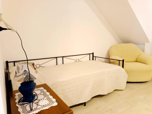 a bedroom with a bed and a yellow chair at Casa Palmieri bilocale Indipendente con Giardino Privato Relax sul Monte Amiata in Castel del Piano