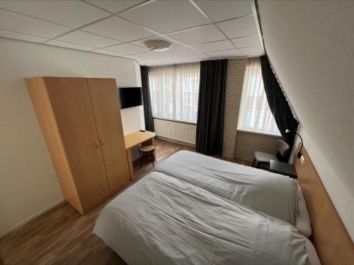 een slaapkamer met een bed en een bureau. bij Appartement 5 in Katwijk aan Zee