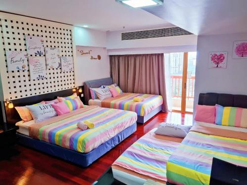 Exclusive Family Suites @ Sunway Pyramid Resort في بيتالينغ جايا: غرفة بثلاث اسرة في غرفة