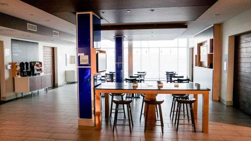 a dining room with a large wooden table and chairs at Holiday Inn Express & Suites Blythe by IHG in Blythe
