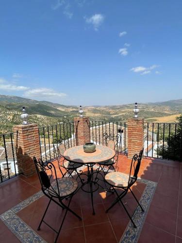 einen Tisch und Stühle auf einer Terrasse mit Aussicht in der Unterkunft Mirador del farmacéutico in Zahara de la Sierra