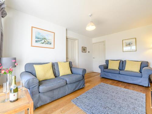 a living room with two blue couches and a table at 2 Orchard Leigh in Austwick