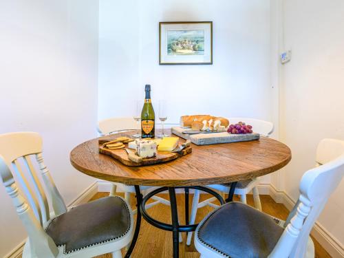 a dining room table with a bottle of wine and grapes at 2 Orchard Leigh in Austwick