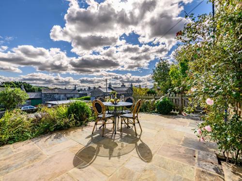 a patio with a table and chairs on a patio at 2 Orchard Leigh in Austwick