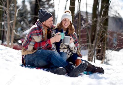 a man and woman sitting in the snow drinking coffee at Cozy Country Farm Stay in Fredonia
