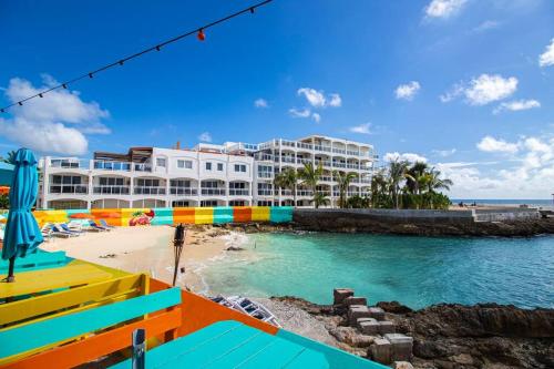 een uitzicht op een resort vanaf het strand bij Sunset Beach View - Luxury Studio next to The Morgan Resort in Maho Reef