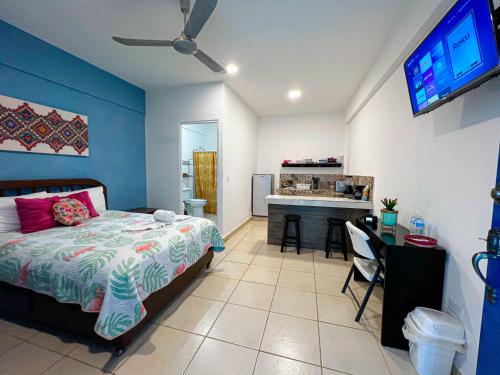 - une chambre avec un lit, un bureau et une télévision dans l'établissement Studios at Main Park Cozumel, à Cozumel
