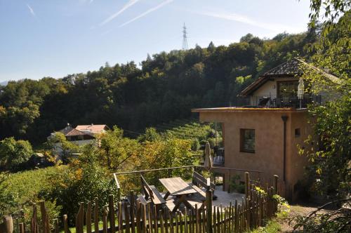 a house with a fence and a table and chairs at Firmelein in Appiano sulla Strada del Vino