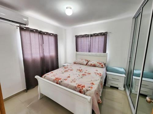 1 dormitorio con cama y espejo. en Precioso apartamento en un complejo residencial con picina, en La Ciénaga