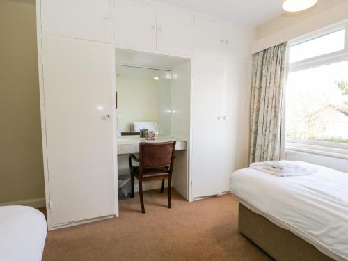 a bedroom with a bed and a desk and a mirror at Silverdale Mount in Grange Over Sands