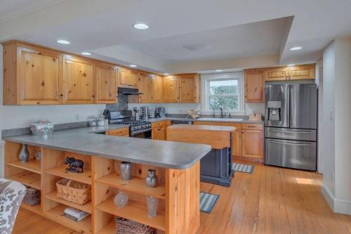 una cocina con armarios de madera y electrodomésticos de acero inoxidable en Huge Farmhouse with Heated Pool for Vacations and Retreats en Roseland