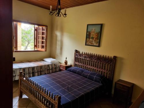 ein Schlafzimmer mit einem blauen Bett und einem Fenster in der Unterkunft Chacara Jequitiba in Itu