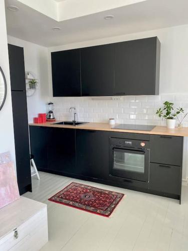 a kitchen with a sink and a stove at Valoisa ja täysin remontoitu huoneisto in Helsinki