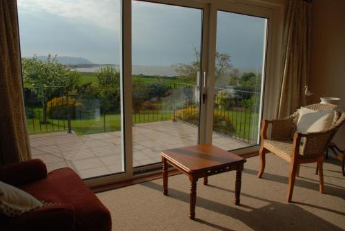 a living room with a large sliding glass door at Meadow View, Blue Anchor in Blue Anchor