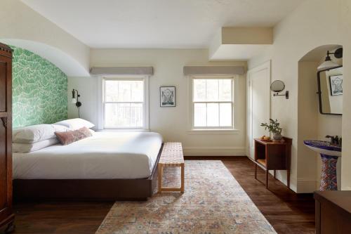 a bedroom with a large bed and two windows at The Stavrand in Guerneville