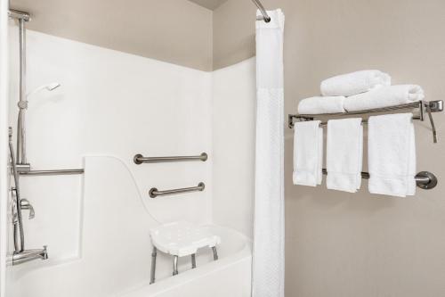 La salle de bains est pourvue d'une douche, d'une baignoire et de serviettes. dans l'établissement Baymont by Wyndham Whitefish, à Whitefish