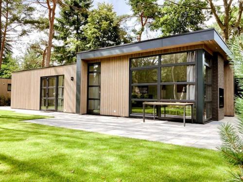 a small house with a table in a yard at Delightful luxury 2-bedroom holiday home in nature in Otterlo
