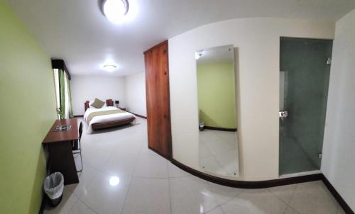 a bathroom with a shower and a bed in a room at Apartahotel Vincent Suites in Pasto