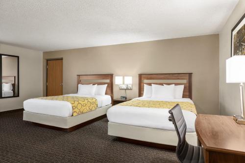 a hotel room with two beds and a desk at Baymont by Wyndham Whitefish in Whitefish
